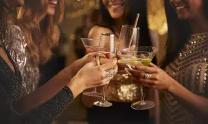 Kobiety w eleganckich strojach wznoszą toasty drinkami. Czy to czas na świętowanie, czy może na rozmowę o lekach jak metypred i alkohol?