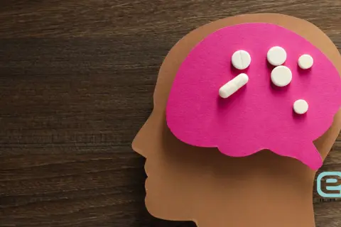 Pigułki na różowym tle w kształcie mózgu, symbolizujące zespół serotoninowy objawy i leczenie.