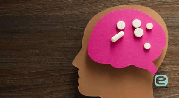 Pigułki na różowym tle w kształcie mózgu, symbolizujące zespół serotoninowy objawy i leczenie.