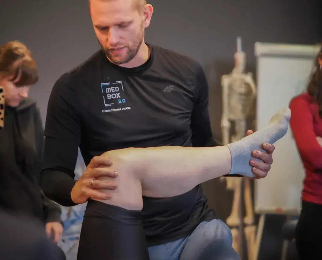fizjoterapeuta na szkoleniu praktycznym lub w trakcie pracy z pacjentem