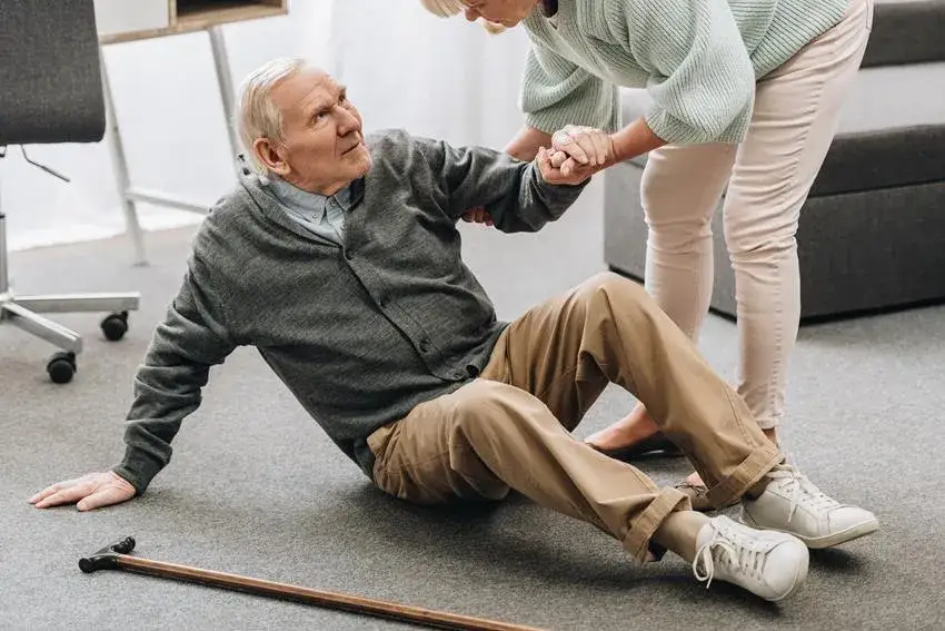 Osoba pomagająca seniorowi po upadku, ocena stanu